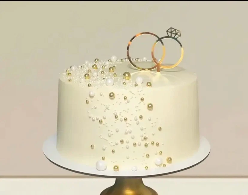 Hochzeitstortenaufleger mit goldenen Ringen